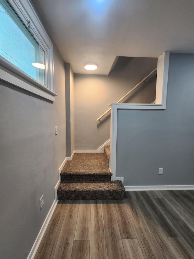 stairway with wood finished floors and baseboards