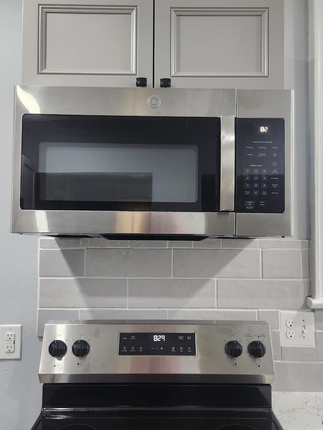 details featuring backsplash, mail area, and stainless steel appliances