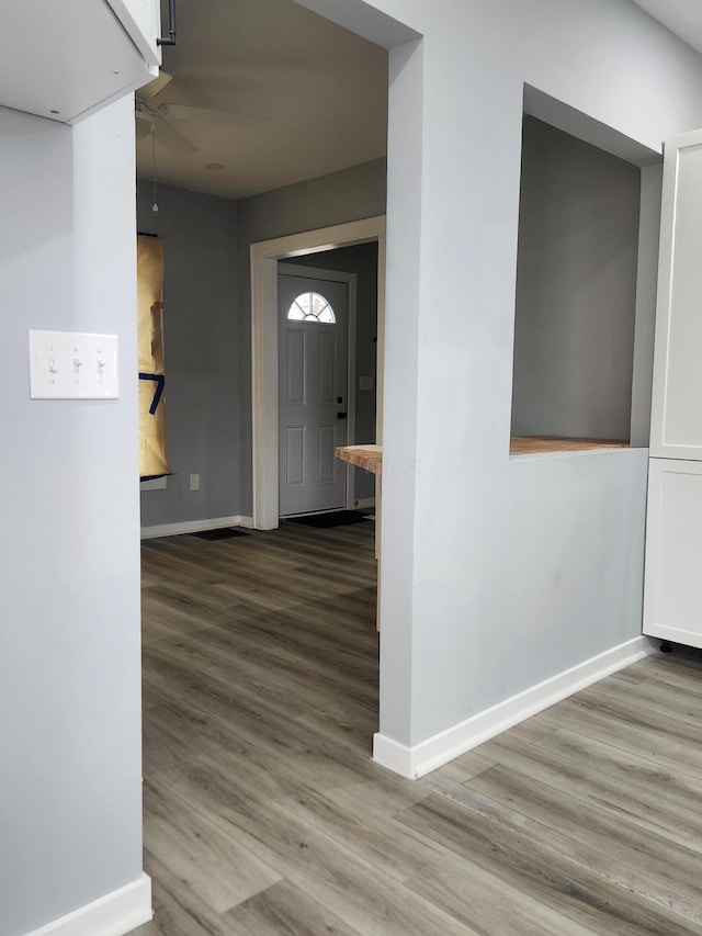 hall with baseboards and wood finished floors