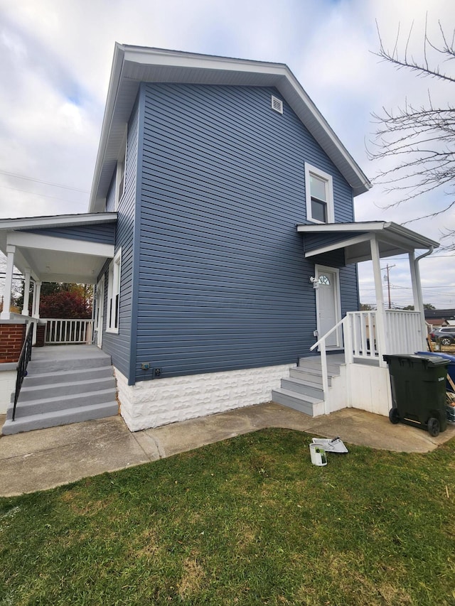 view of side of property with a lawn and a porch