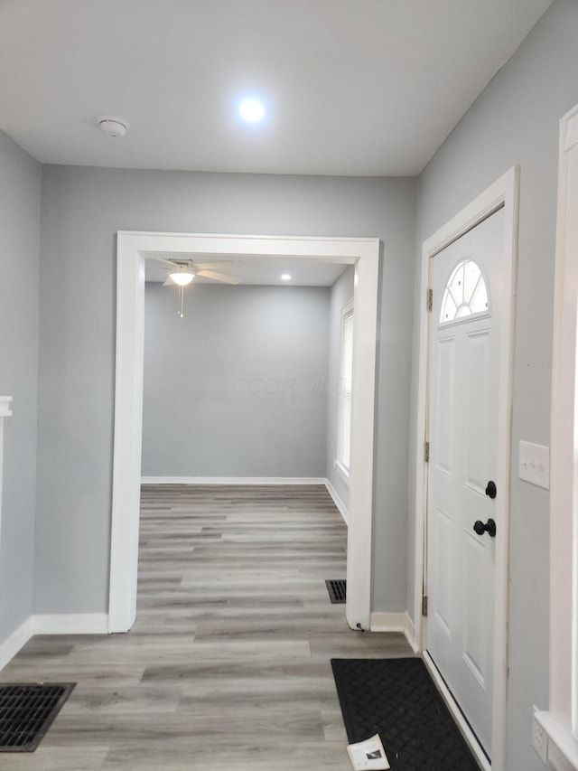 foyer with visible vents, baseboards, wood finished floors, and a ceiling fan