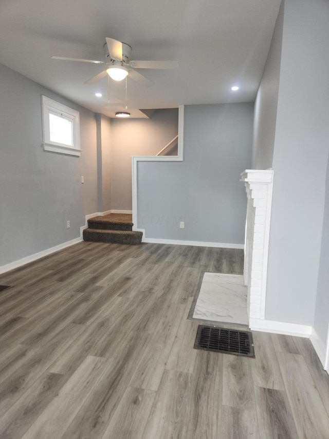 basement with visible vents, a ceiling fan, wood finished floors, stairway, and baseboards