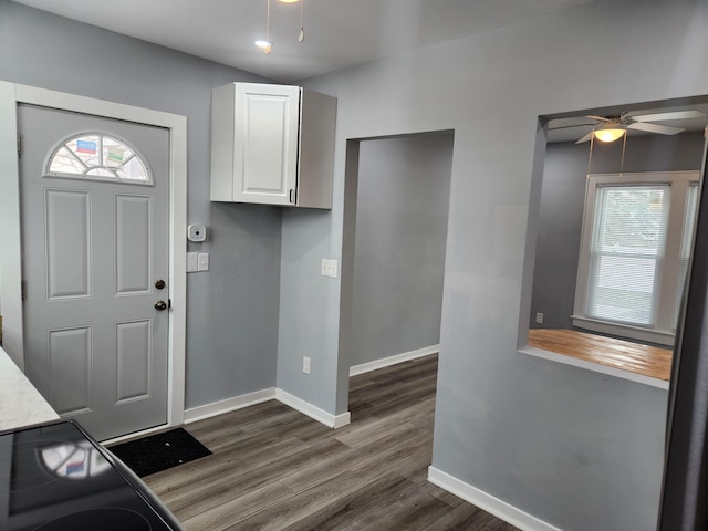 entryway featuring baseboards, ceiling fan, and dark wood finished floors