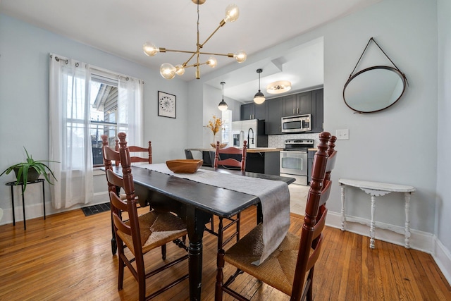 dining area with hardwood / wood-style flooring and an inviting chandelier