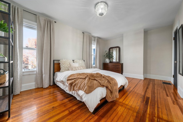 bedroom with hardwood / wood-style floors and multiple windows