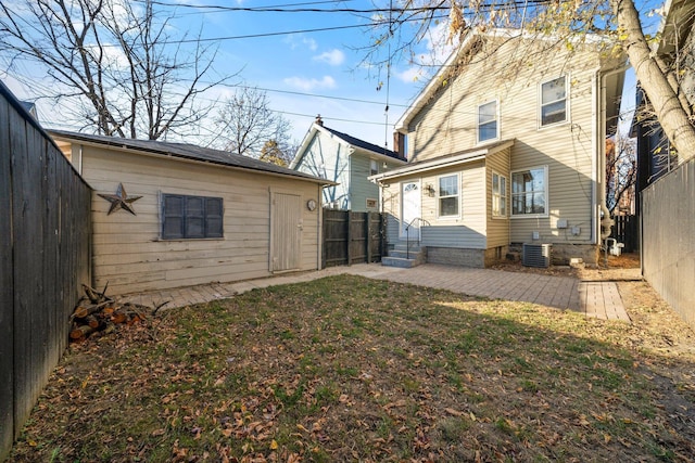 back of property with cooling unit and a yard