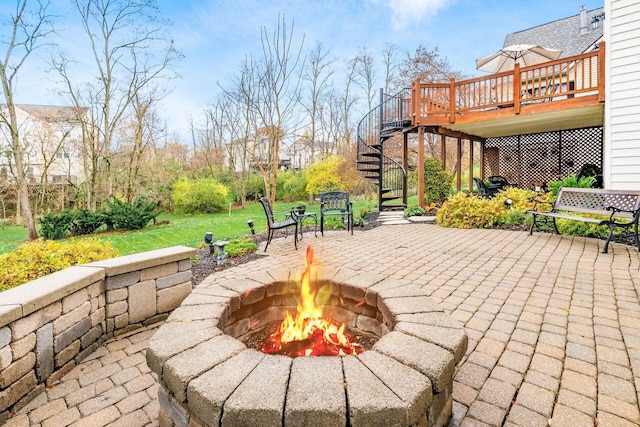 view of patio / terrace with a wooden deck and a fire pit