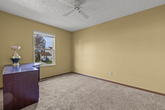 carpeted office featuring a textured ceiling and ceiling fan