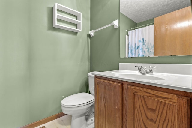 bathroom featuring vanity, a textured ceiling, and toilet