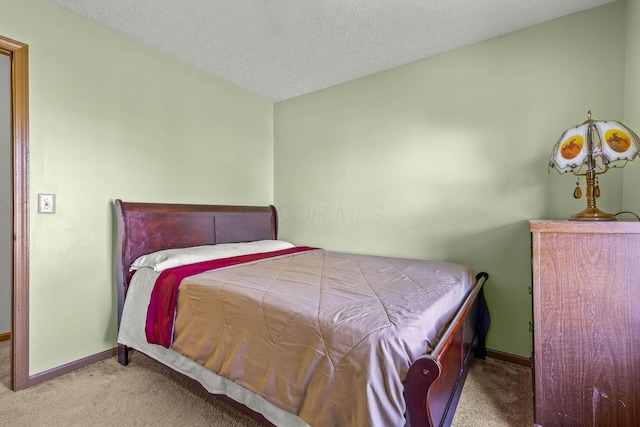 bedroom featuring light colored carpet and a textured ceiling