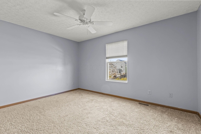 carpeted spare room with ceiling fan and a textured ceiling