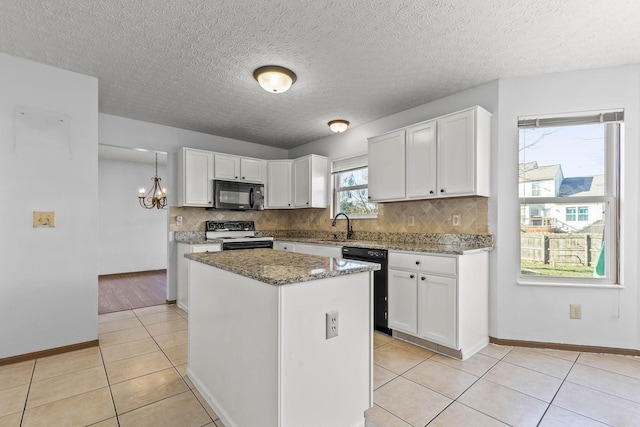 kitchen featuring dark stone counters, white cabinets, black appliances, and a kitchen island