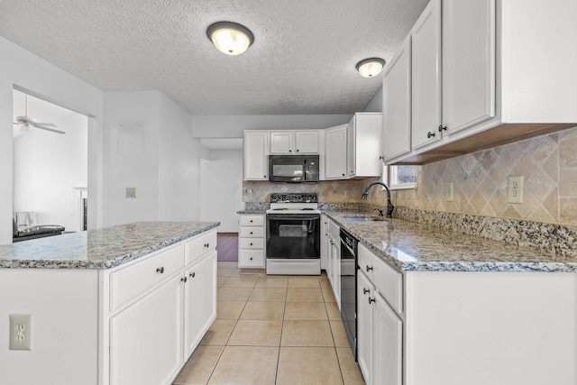 kitchen featuring white cabinets, sink, light stone counters, and black appliances