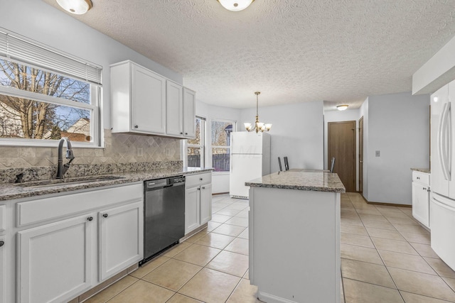 kitchen featuring a center island, sink, black dishwasher, light stone counters, and white cabinetry