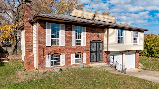 raised ranch with a front yard and a garage