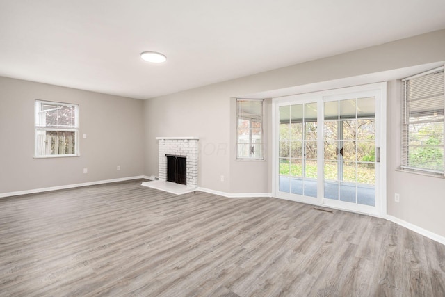 unfurnished living room featuring a fireplace and light hardwood / wood-style floors