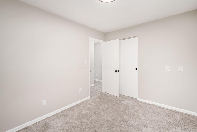 unfurnished bedroom with light carpet and a closet