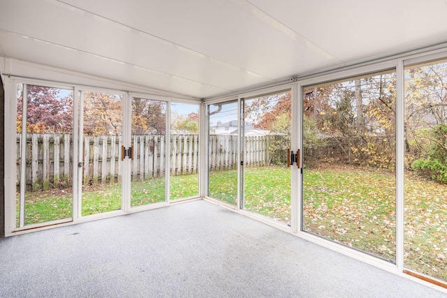 unfurnished sunroom featuring vaulted ceiling and a healthy amount of sunlight