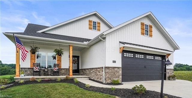 view of front of house with covered porch, a front yard, and a garage