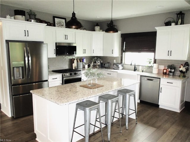 kitchen featuring white cabinetry, a center island, and stainless steel appliances