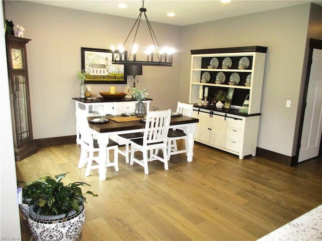 dining space featuring hardwood / wood-style flooring and a notable chandelier