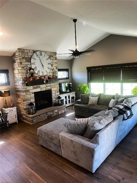 living room featuring a fireplace, ceiling fan, dark hardwood / wood-style flooring, and vaulted ceiling