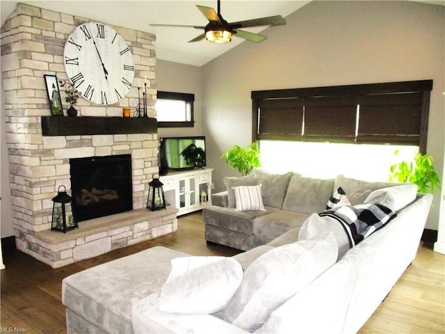 living room with a fireplace, hardwood / wood-style floors, vaulted ceiling, and ceiling fan