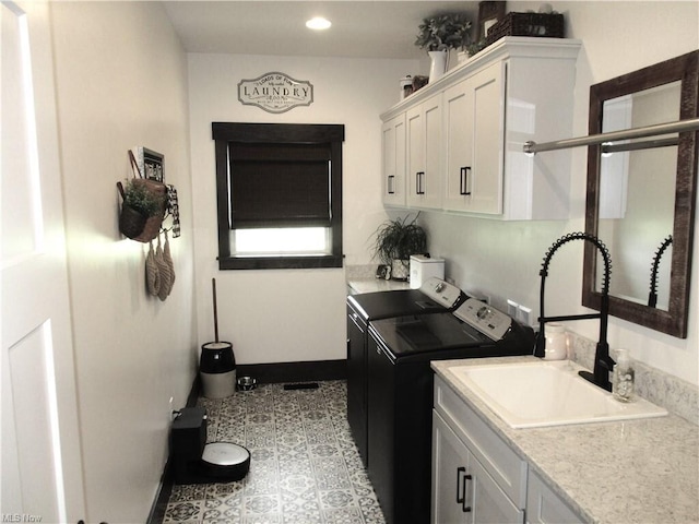 washroom featuring cabinets, sink, and washing machine and clothes dryer