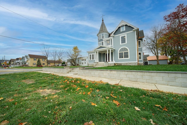 victorian-style house with a front lawn