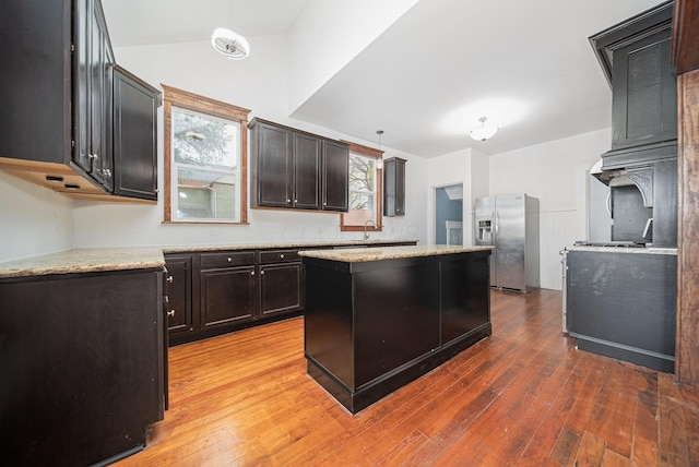 kitchen with a center island, stainless steel fridge, dark hardwood / wood-style flooring, and pendant lighting