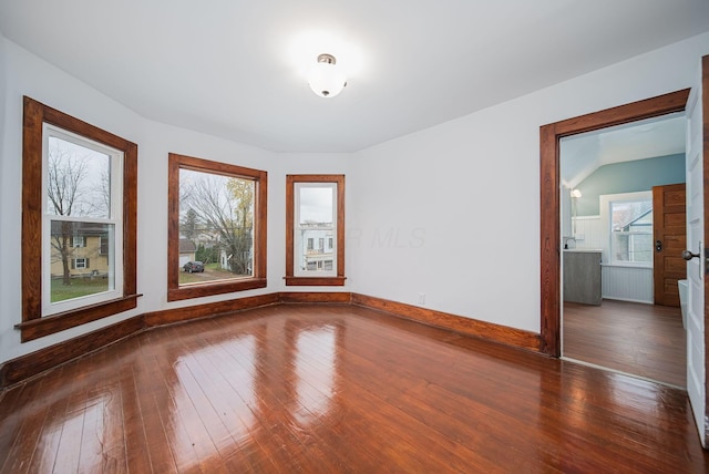 unfurnished room featuring plenty of natural light and dark hardwood / wood-style floors