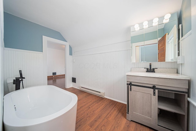 bathroom featuring vanity, vaulted ceiling, a tub to relax in, a baseboard radiator, and wood-type flooring