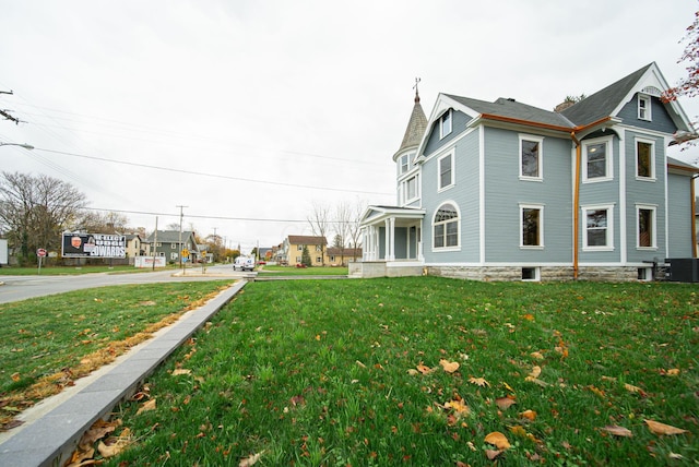 view of side of property with central AC unit and a yard