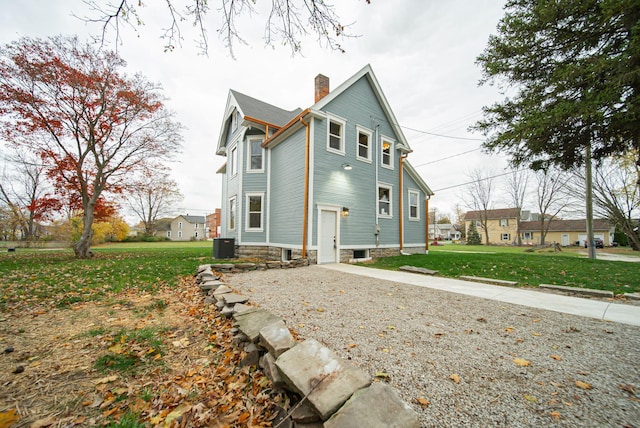 view of side of property featuring a yard and central AC unit