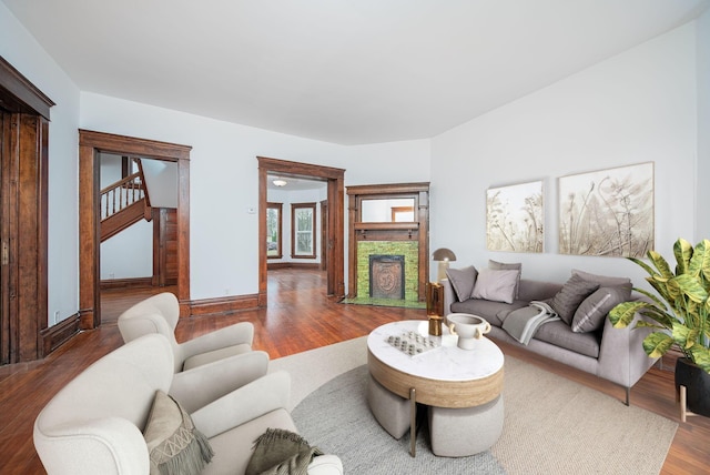 living room with a stone fireplace and hardwood / wood-style floors