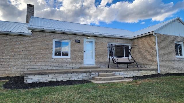 view of exterior entry with a yard