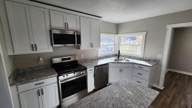 kitchen featuring white cabinets, sink, dark hardwood / wood-style floors, appliances with stainless steel finishes, and light stone counters