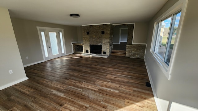 unfurnished living room with hardwood / wood-style flooring and a brick fireplace