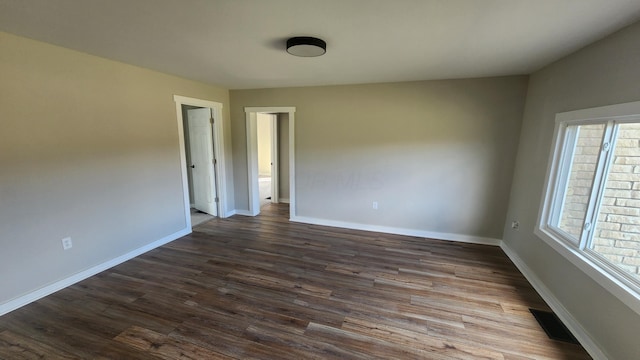 unfurnished room with dark wood-type flooring