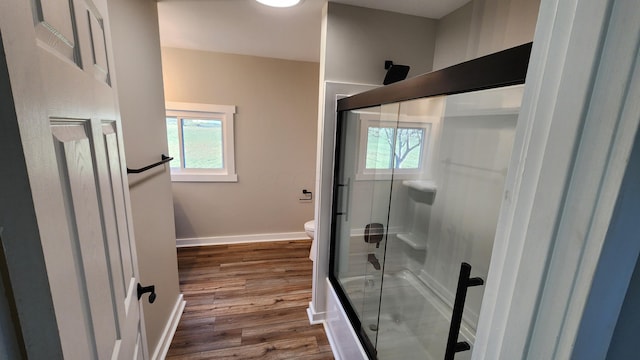 bathroom featuring hardwood / wood-style floors, toilet, and walk in shower