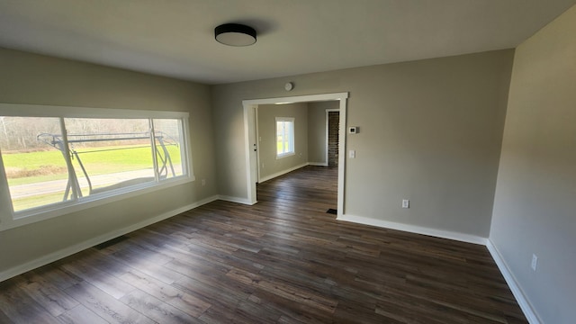 empty room with dark hardwood / wood-style flooring