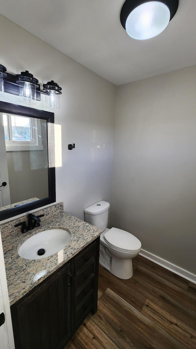 bathroom with vanity, hardwood / wood-style flooring, and toilet