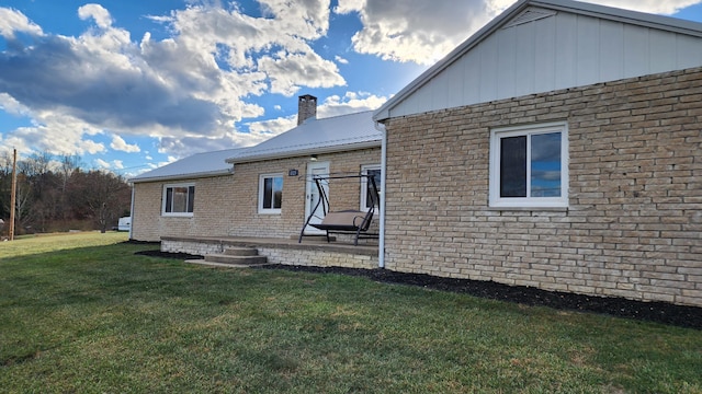 back of property featuring a lawn