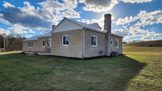 view of side of property featuring a yard and central air condition unit