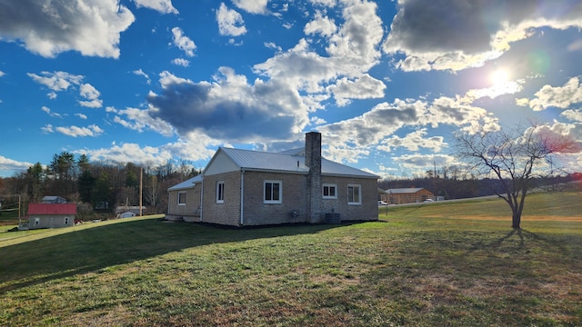 view of side of property with a lawn and central air condition unit