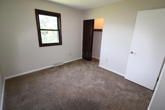 unfurnished bedroom with dark colored carpet