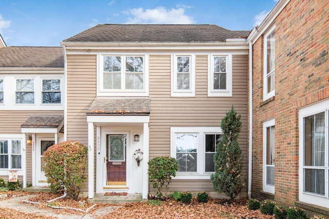 townhome / multi-family property with a shingled roof