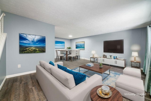 living room with dark wood-style floors, baseboards, and a textured ceiling