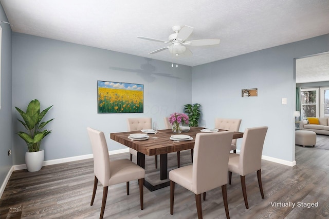 dining area featuring dark wood-style floors, a ceiling fan, baseboards, and a textured ceiling