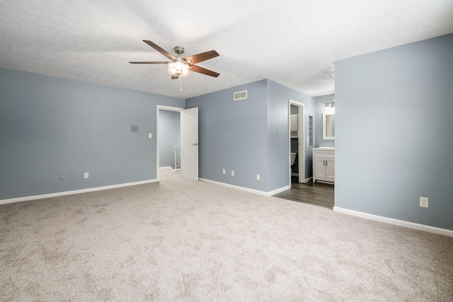 interior space with a textured ceiling, a ceiling fan, visible vents, and baseboards